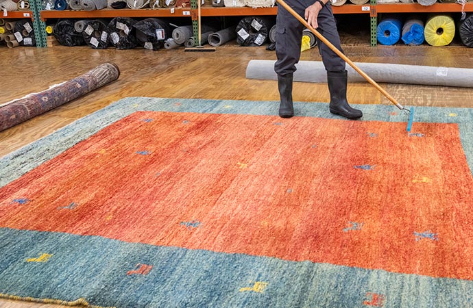 indoor rug cleaning broom dust man orange
