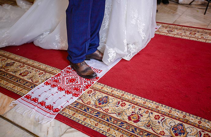 newlyweds step on the red wedding rug